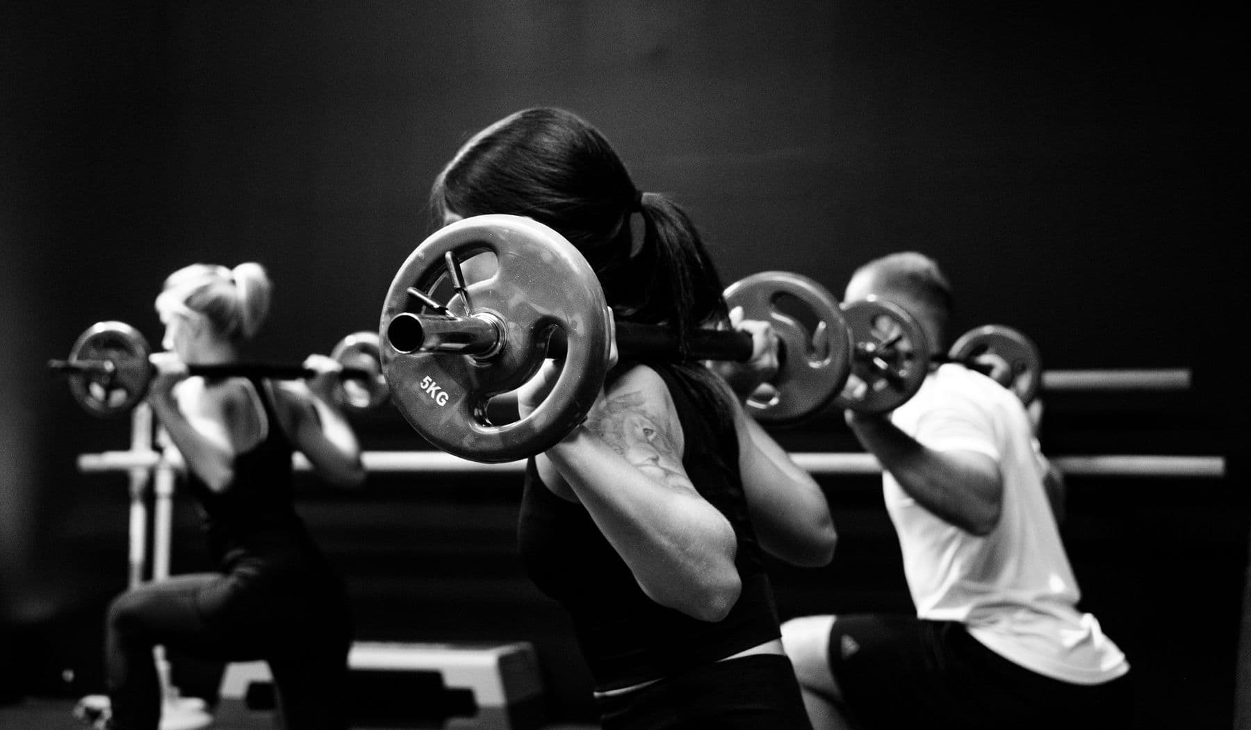 A coach-led barbell class mid-squat